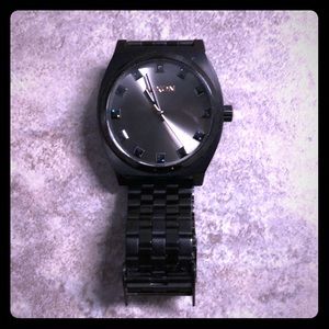 Nixon black steel watch with crystal dials.
